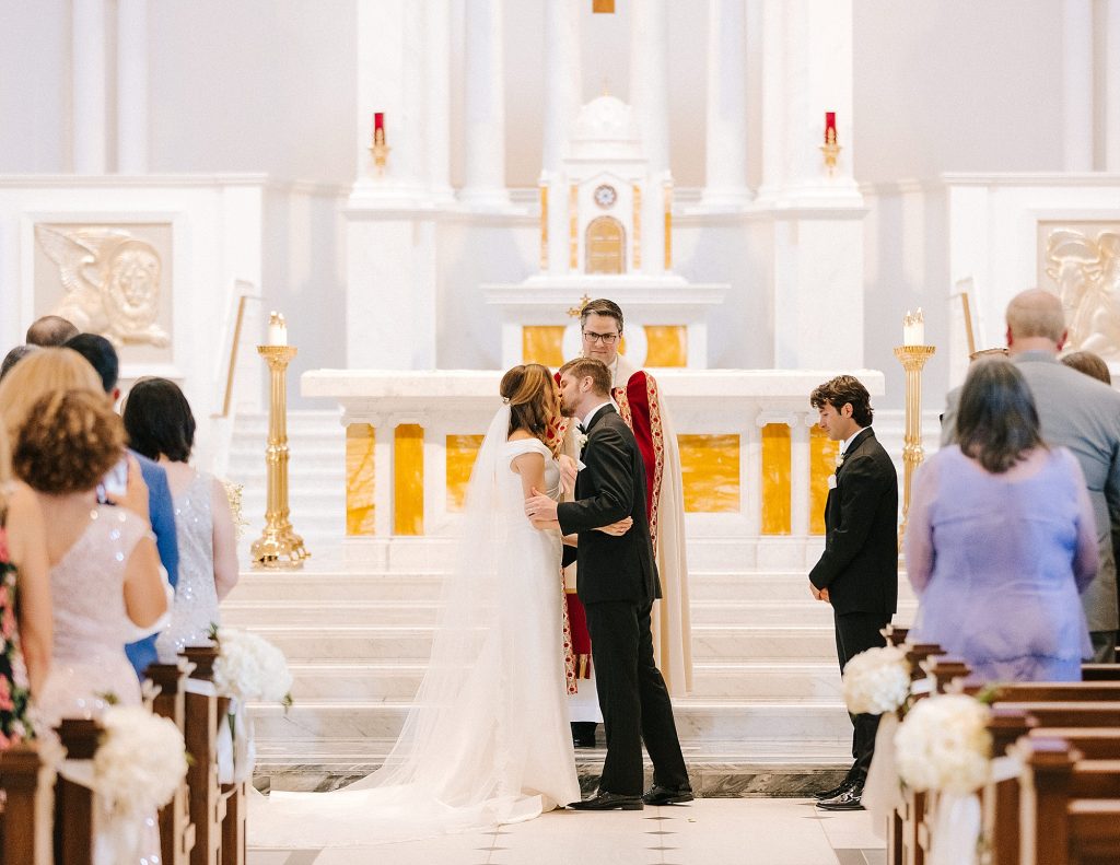 bride and groom kiss during traditional church wedding in Raleigh NC