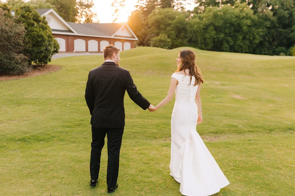 bride and groom hold hands walking towards Prestonwood Country Club