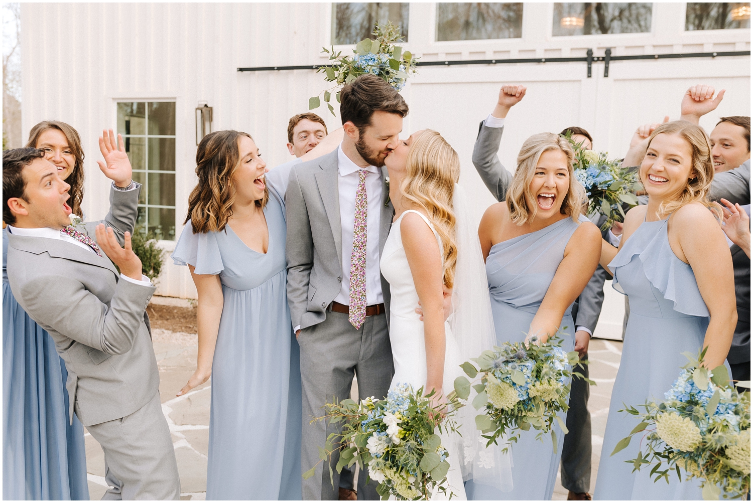 A couple is surrounded with cheers from their wedding party at Carolina Grove in Raleigh, NC