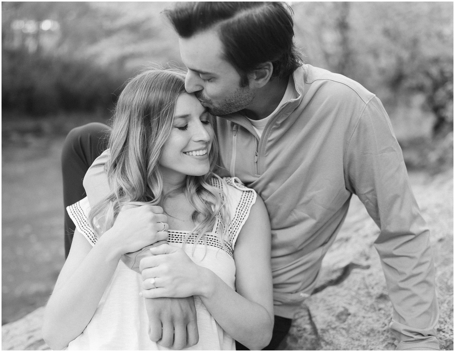 A couple snuggles close for their engagement session at Freedom Park in Charlotte, NC