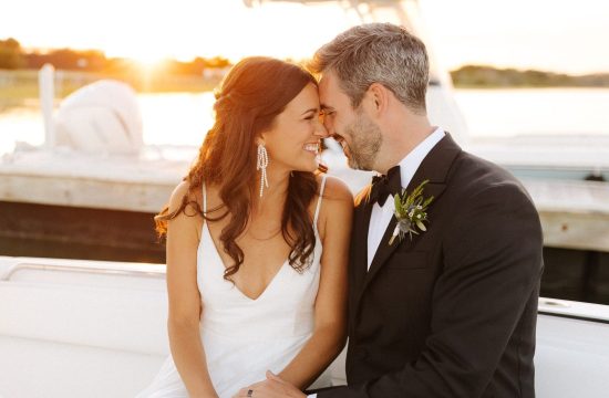 Couple sits on a boat at sunset on their wedding day at Figure Eight Island