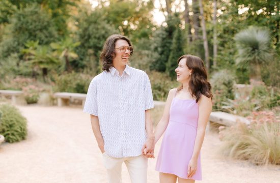 a couple laughs together during their engagement session at Duke Gardens in Durham, NC