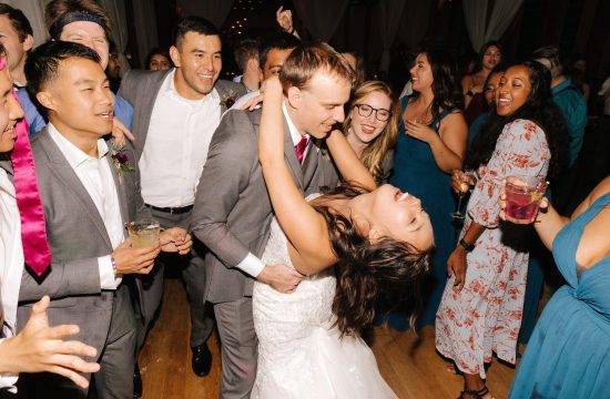 A couple partys with their guests on the dance floor during their wedding at The Cotton Room in Durham, NC