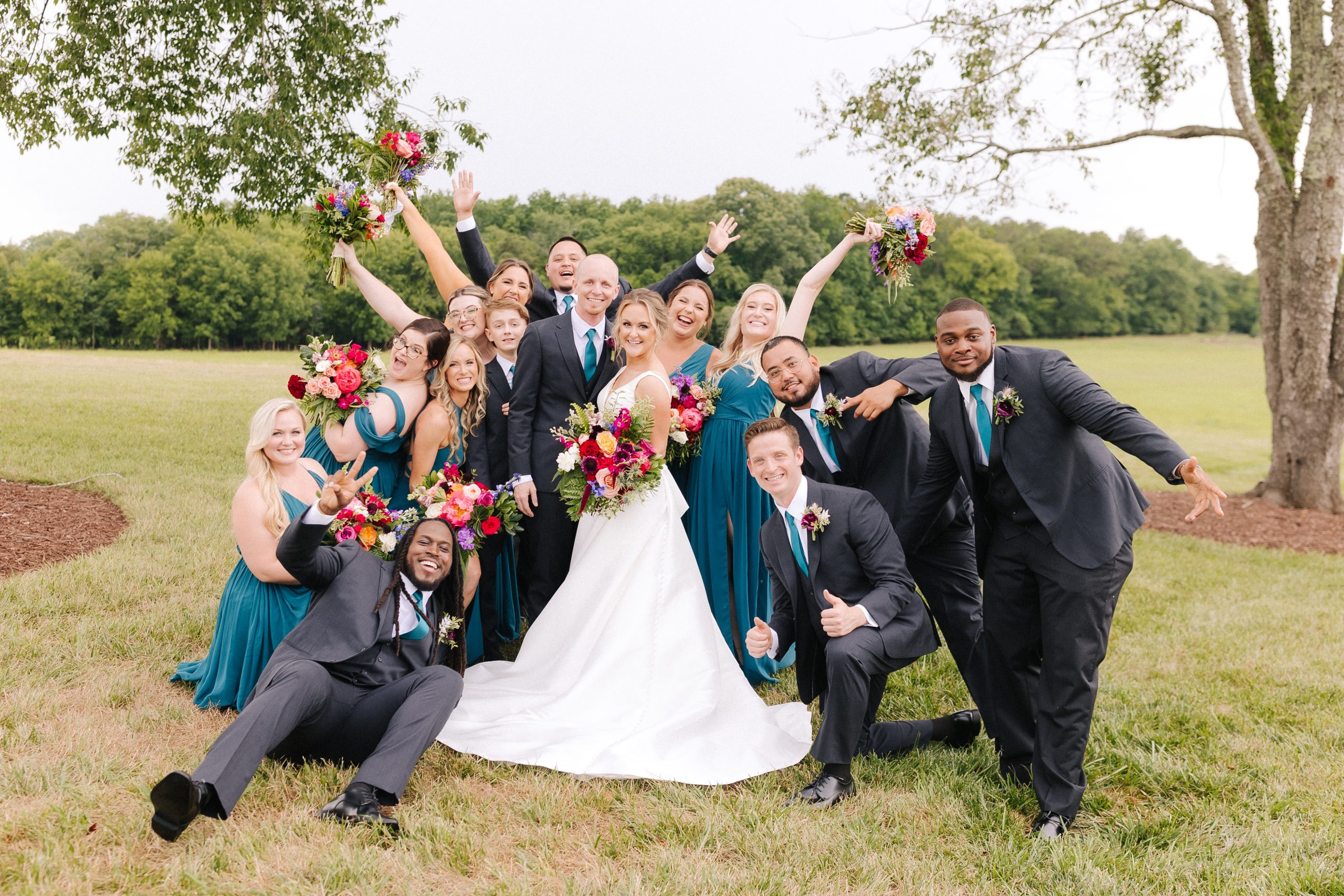 A couple celebrates with their wedding party on their wedding day at Board & Batten Events in Lexington, NC
