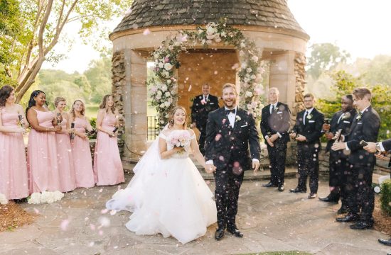 A couple walks through floral confetti after saying I Do at Graylyn Estate in Winston-Salem, NC