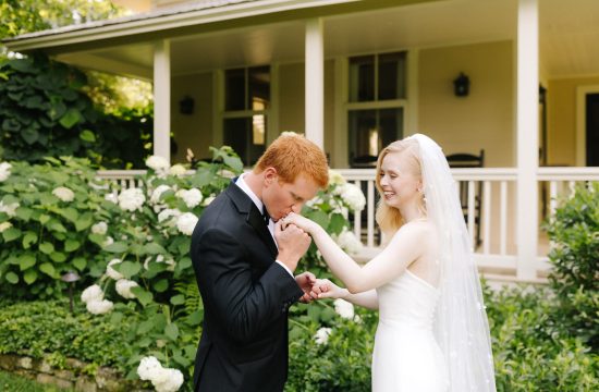 Groom Kisses Bride on the hand during their first look at Old Edwards Inn in Highlands, North Carolina